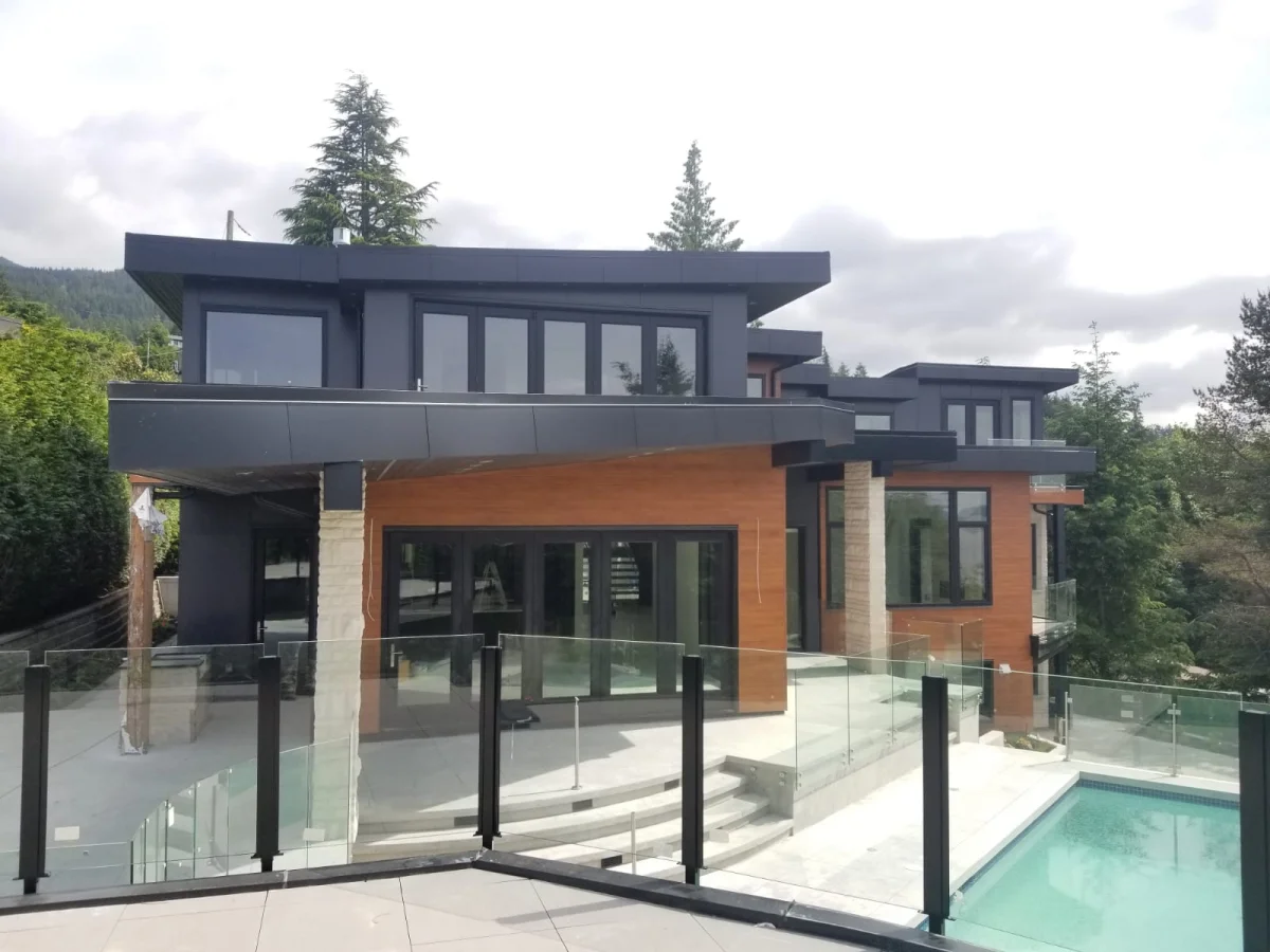 West Vancouver luxury home with dark metal cladding, wood siding, glass pool railings by Nixon Exteriors