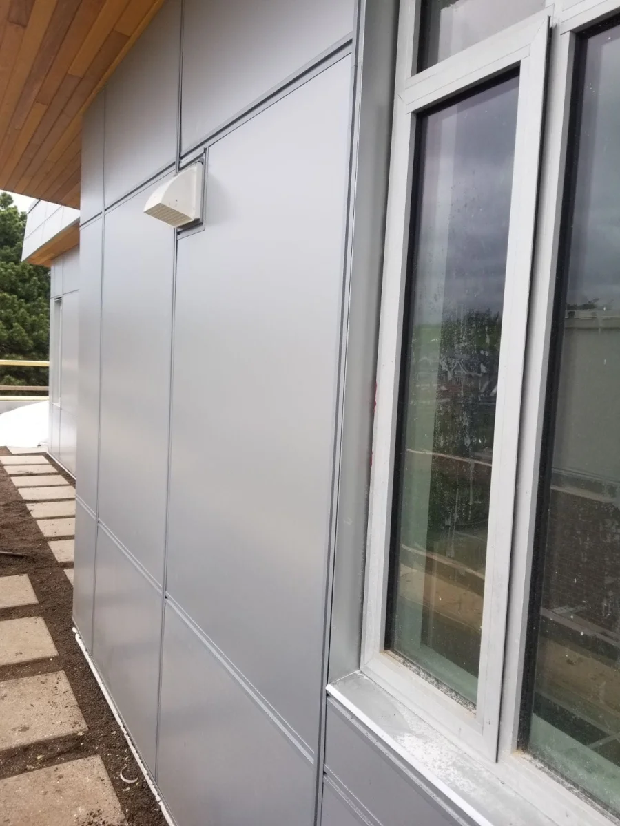 Silver metal cladding panels with cedar soffit and window detail by Nixon Exteriors in Vancouver BC